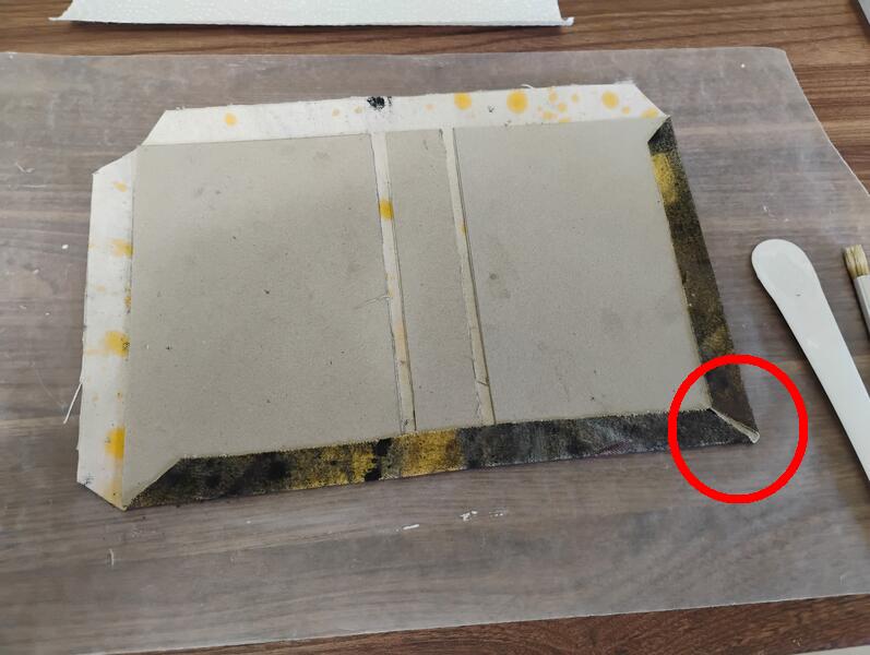 This image shows the error caused by incorrectly measuring the corner cuts of the cloth for the cover. The angled cut should be made about 6mm off the corner of the cardboard, but I went with 3mm without thinking about it. Oops.