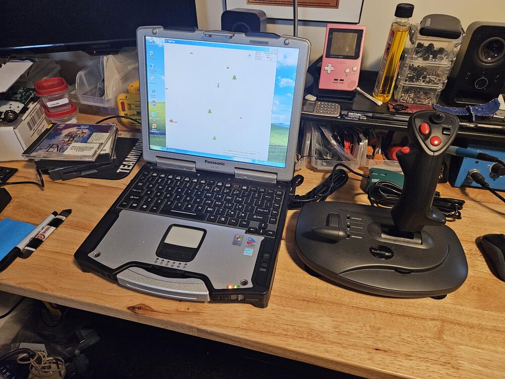 The Toughbook shown open and playing SkiFree with a Radio Shack FlighT Stick because disc 2 for Microsoft Flight Simulatir 2000 is missing!